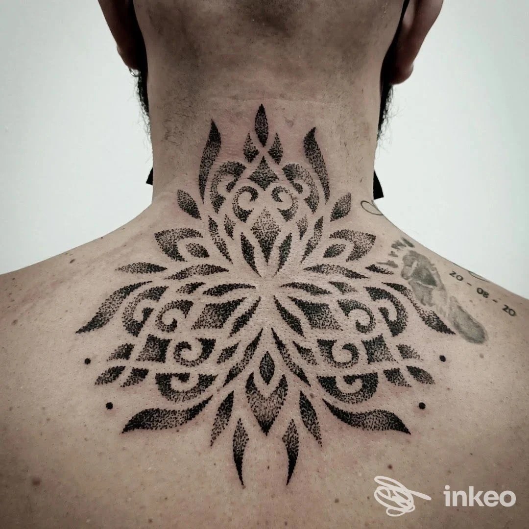Tattoo geometrico nero sul collo e sulla parte superiore della schiena, eseguito probabilmente da Migart Tattoo a Reggio Emilia.