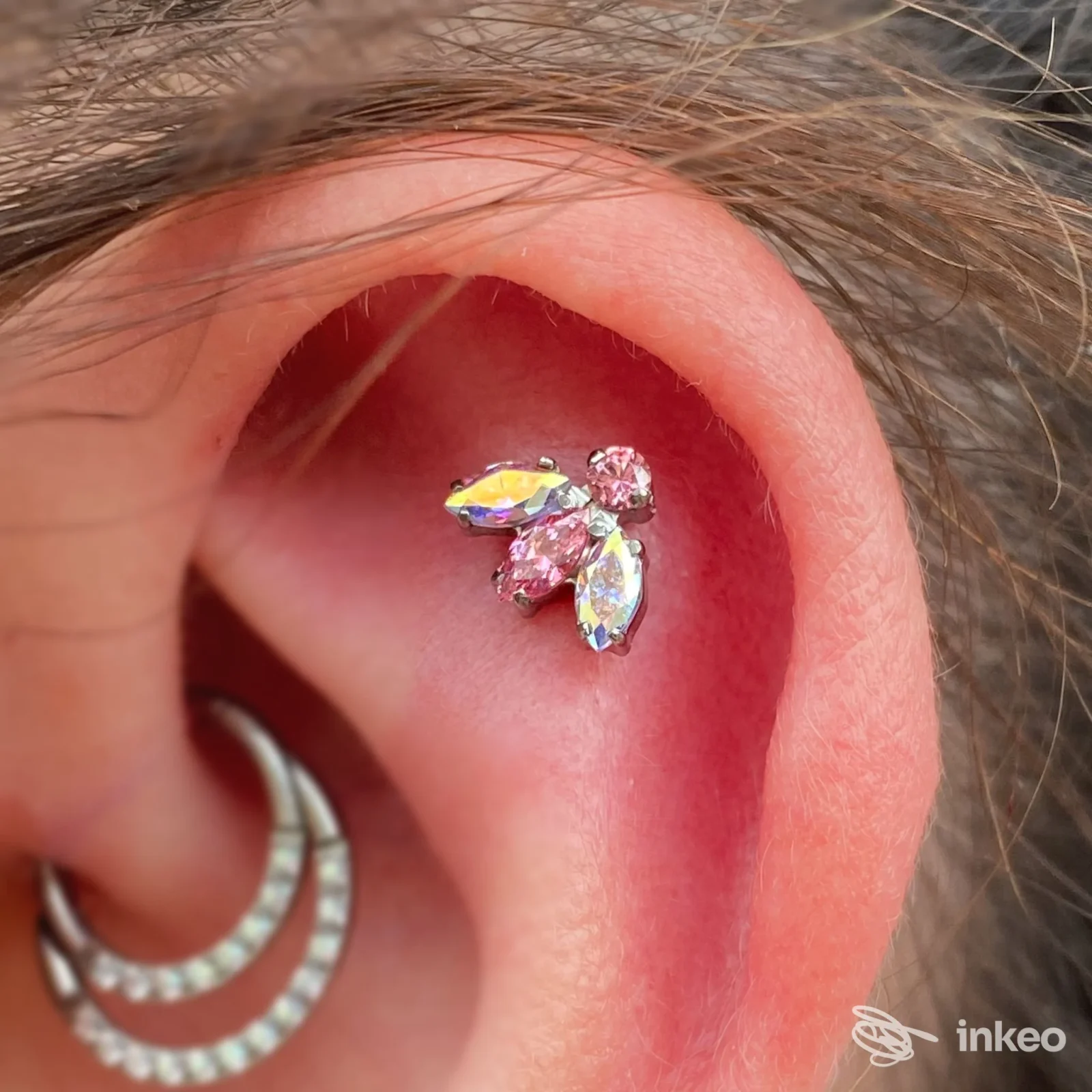 Primo piano di un piercing nella conca con gioielli cristallini, foto fornita da Moncy Art - Boutique Del Piercing, Gambettola.