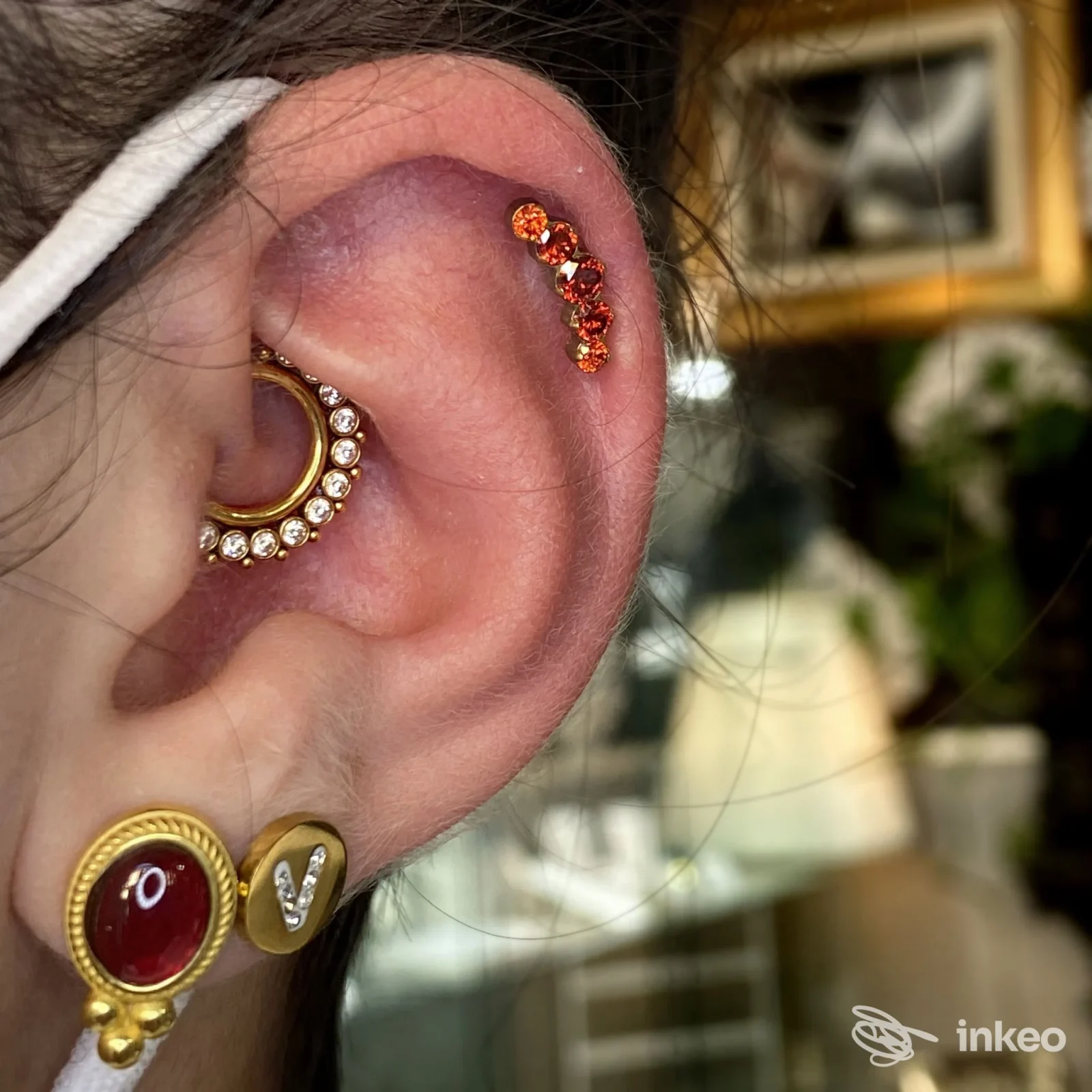 Primo piano di un orecchio con multipli piercing gioiello realizzati da Moncy Art - Boutique Del Piercing a Gambettola.