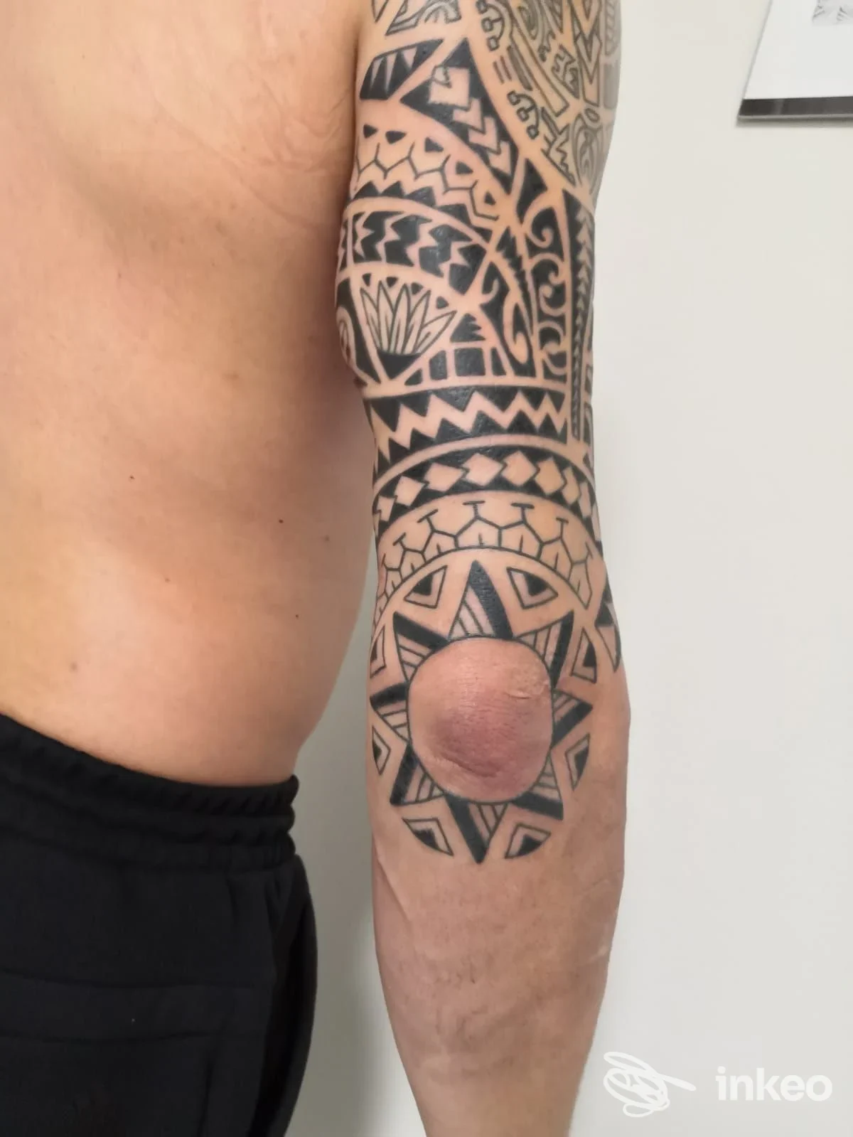 Braccio tatuato con ampio motivo geometrico fino al gomito, fotografato presso Image Studio Simone Tattoo a Fossa.