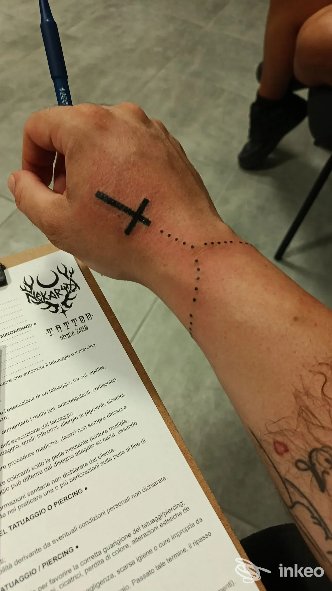 Mano e polso tatuati con una croce nera e puntini, foto fornita da Nekarya Tattoo, Mirandola.