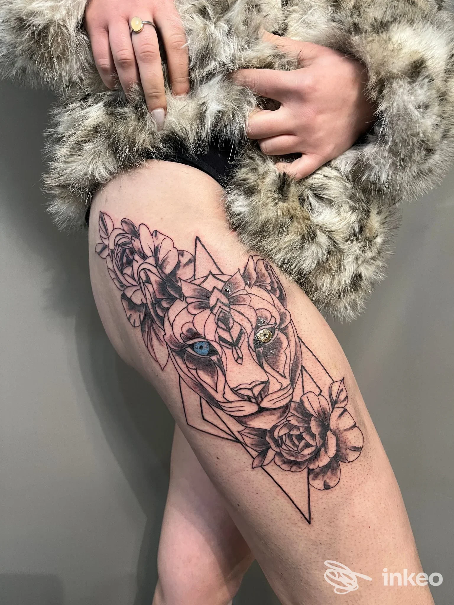 Ampio tatuaggio a tema leone e fiori sulla coscia, foto fornita da Schink Tattoo & Schira Design, Santa Maria Nuova.