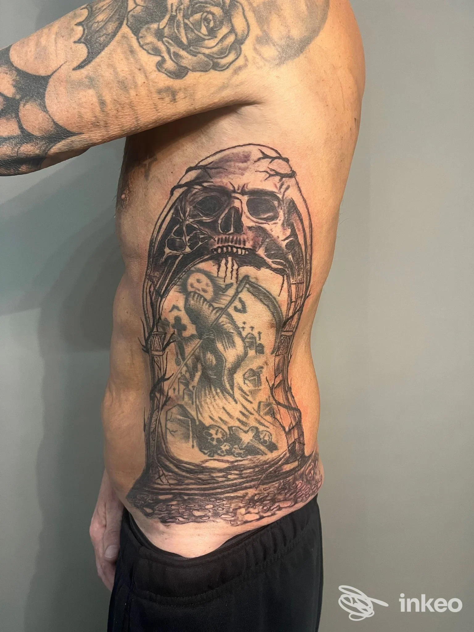 Tatuaggio realistico a tutto fianco con teschio e scena interna, Schink Tattoo & Schira Design, Santa Maria Nuova.