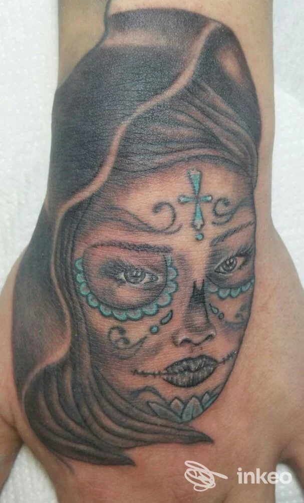 Tatuaggio sul dorso della mano raffigurante un volto femminile in stile sugar skull, opera di Carmen e Max Tattoo a Castelnuovo Rangone.