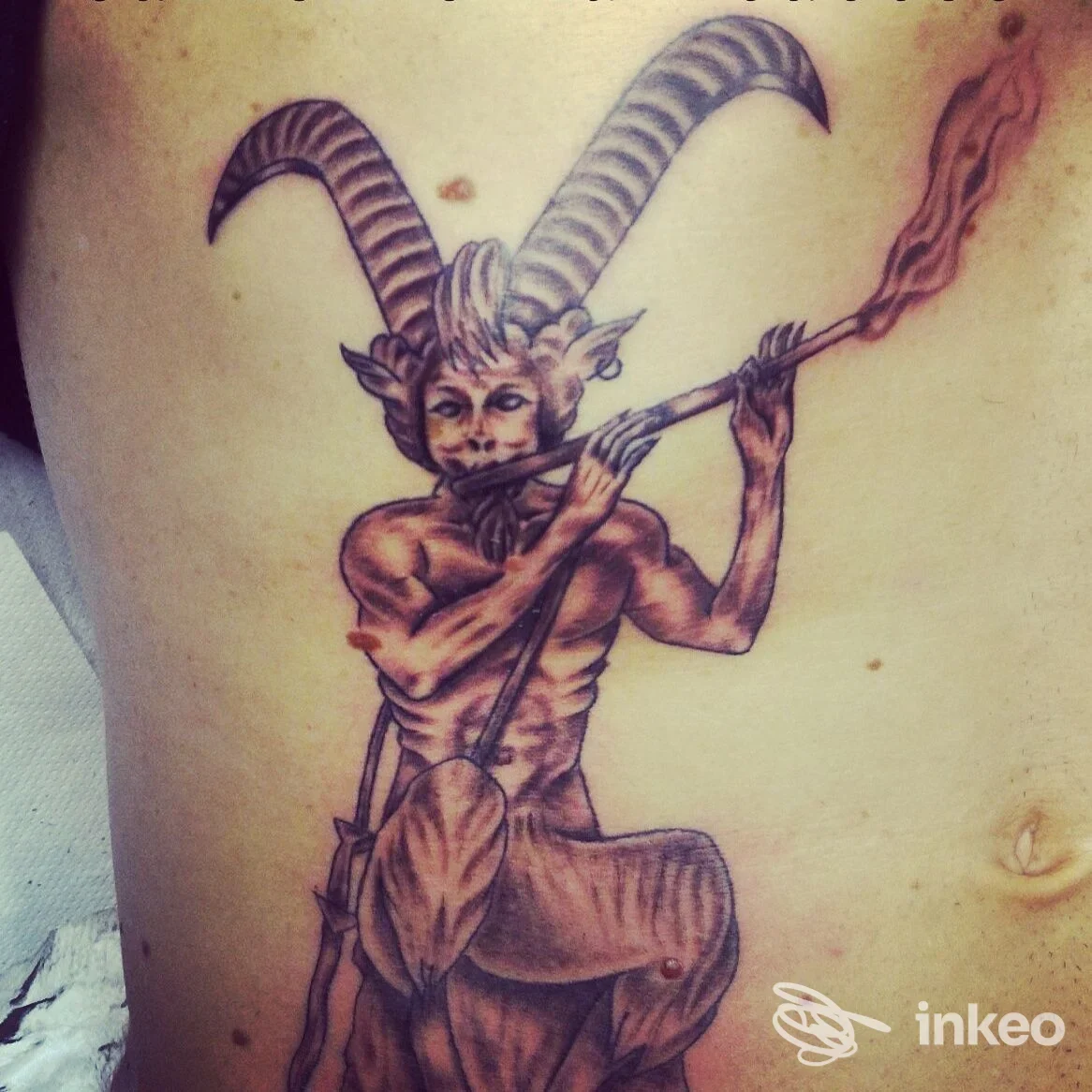 Tatuaggio su fianco/torace raffigurante una figura cornuta che suona uno strumento, realizzato da Carmen e Max Tattoo a Castelnuovo Rangone.