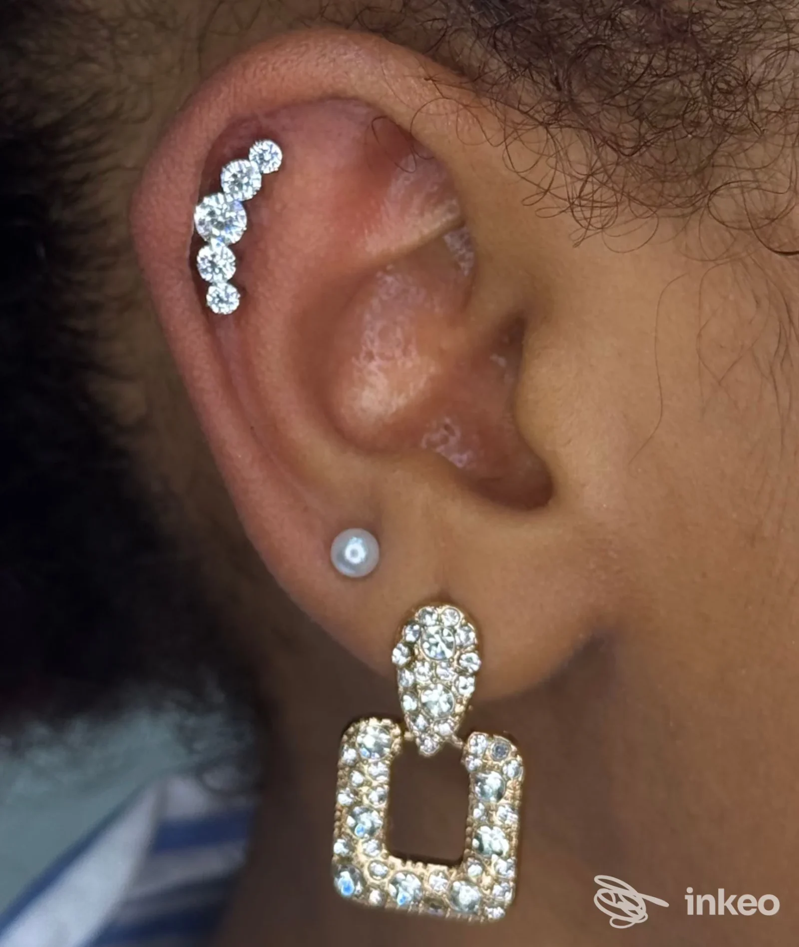 Primo piano di orecchio con piercing elice e lobo con gioielli, foto fornita da Piercer Albert, Rimini.
