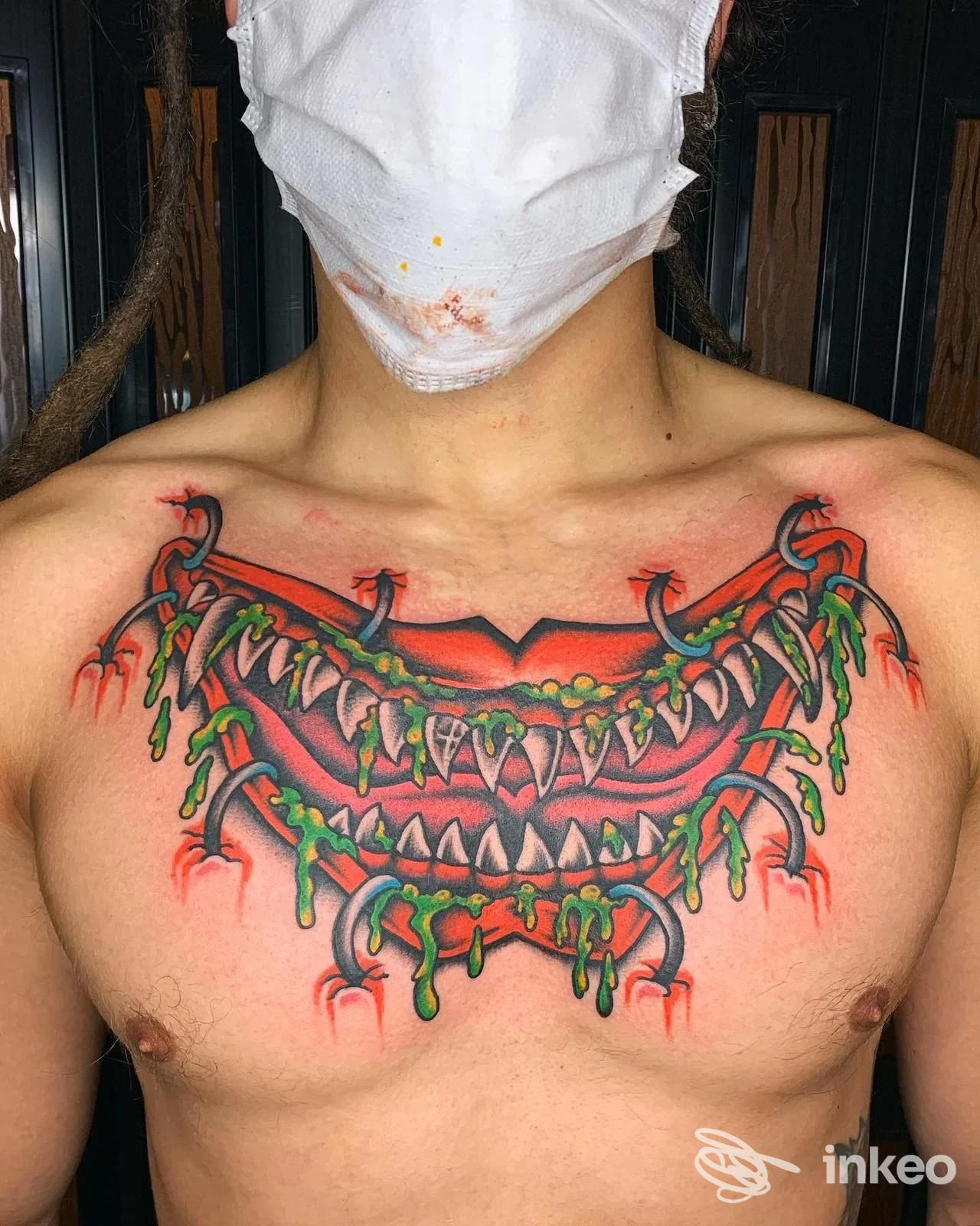 Tatuaggio al centro del petto con tre file di mascelle dentate e scorie verdi, foto inviata da Franky's Tattoo Shop, Piacenza.
