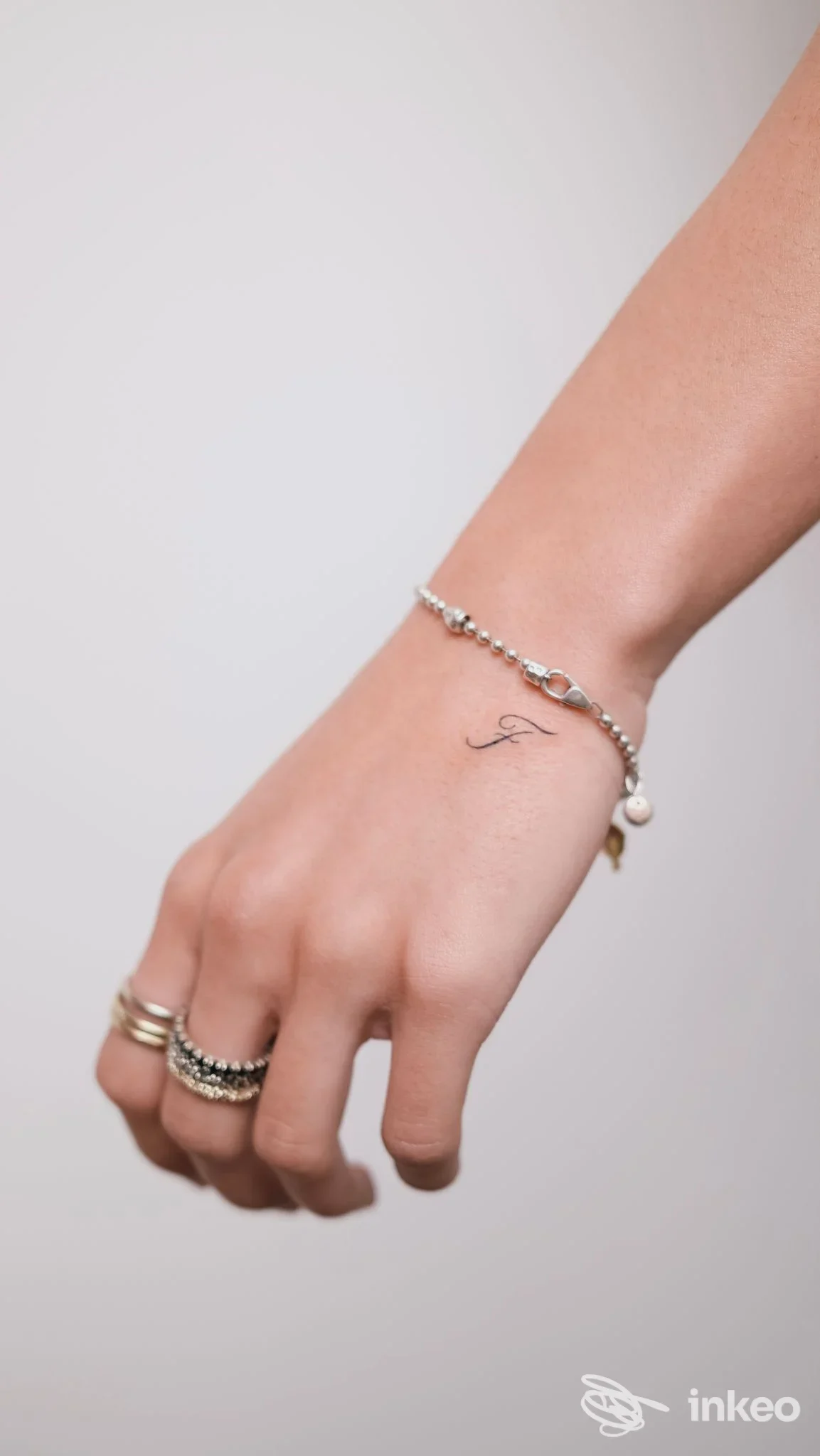 Primo piano del dorso mano con piccolo tatuaggio a forma di lettera 'F'. Foto fornita da Klinti Studio, Modena.