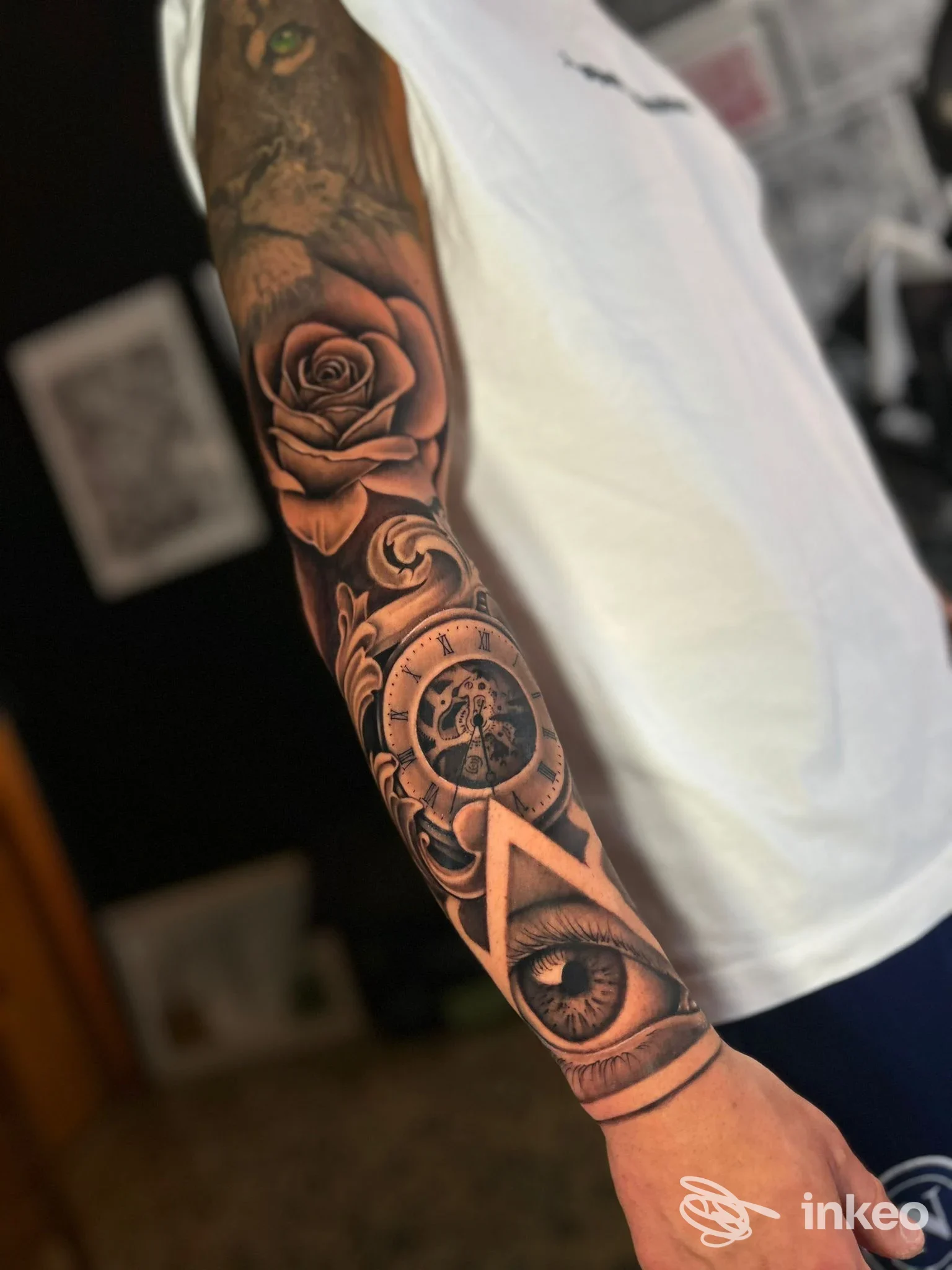 Manica tatuata con rosa, orologio e occhio realista, foto North Side Ink Club a Reggio nell'Emilia.