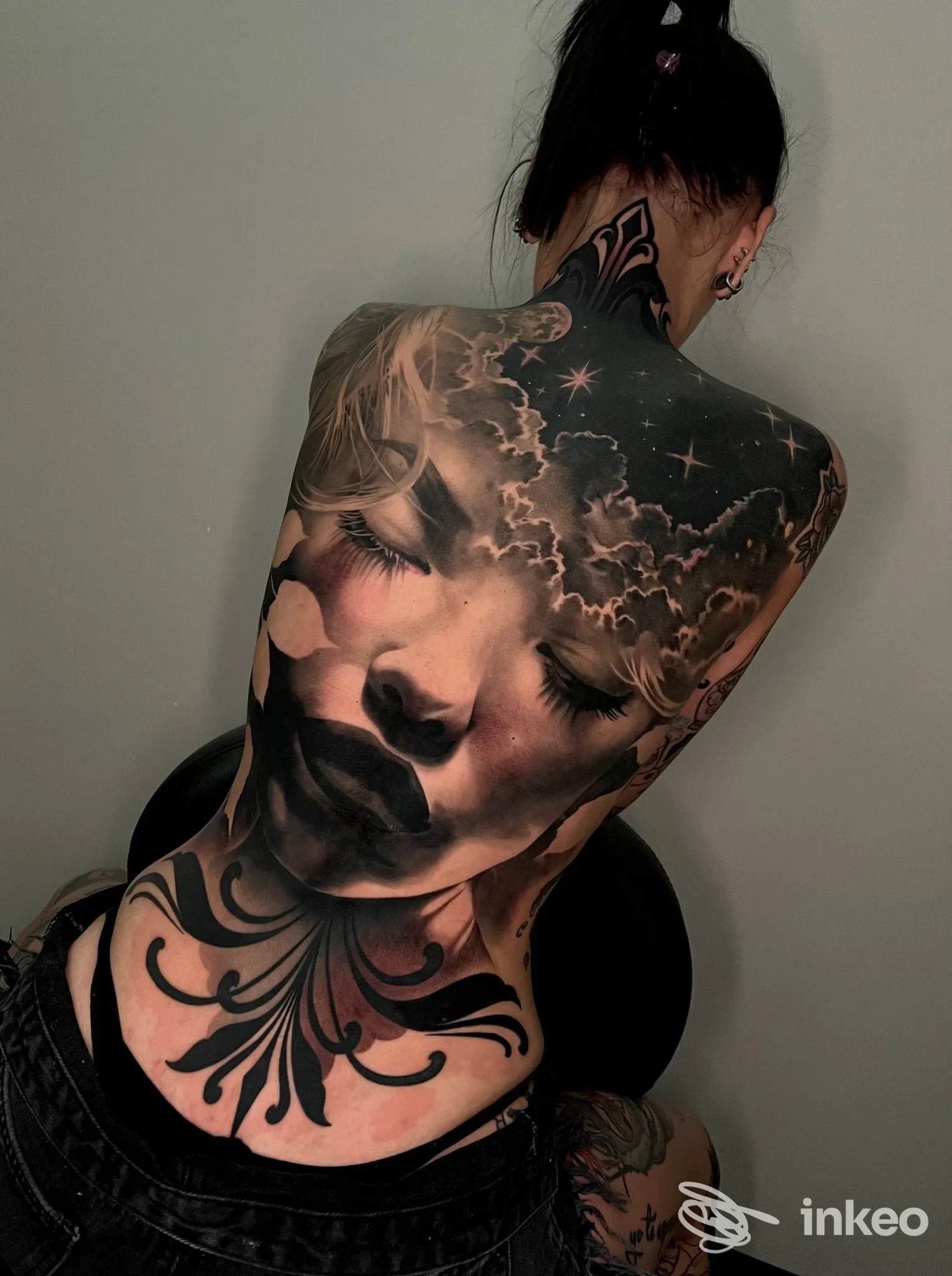 Grande tatuaggio realistico a schiena intera con volto e elementi celesti, foto fornita da SelfMade Tattoo, Lemignano.