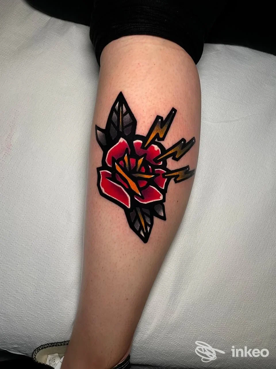 Tatuaggio su polpaccio: rosa stilizzata con fulmini, foto dal Bridge tattoo a Rimini.