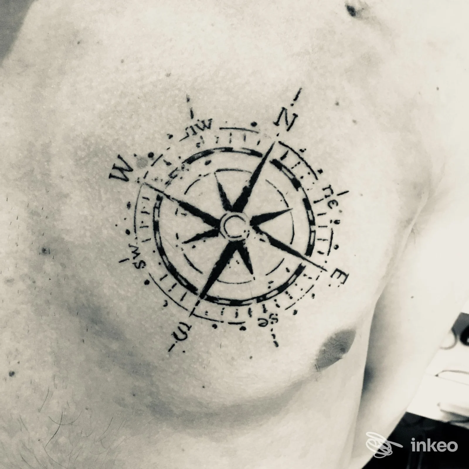 Tatuaggio di una bussola sul petto, fotografia di lavoro realizzato presso DermaUp a Budrio, dettaglio della pelle e del disegno inchiostrato.