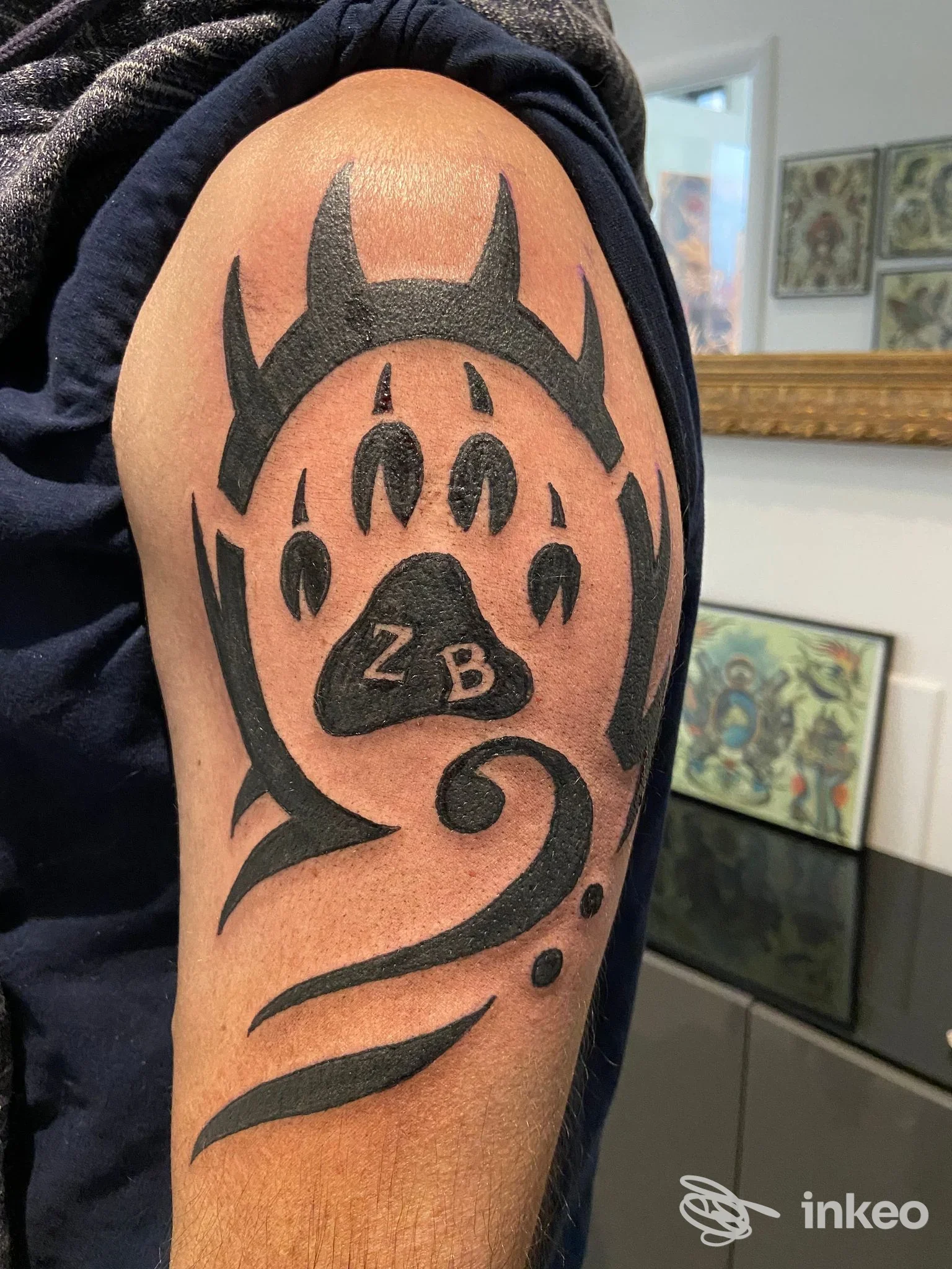 Tatuaggio blackwork su spalla/alto braccio con motivo astratto e zampa, fotografia di Max Tattoo a Casalecchio di Reno.