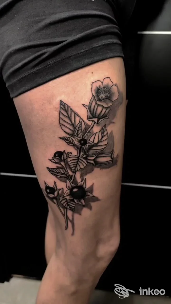 Tatuaggio floreale in bianco e nero su coscia, foto caricata dallo studio Snakeman Tattoo & Piercing a Cesenatico.
