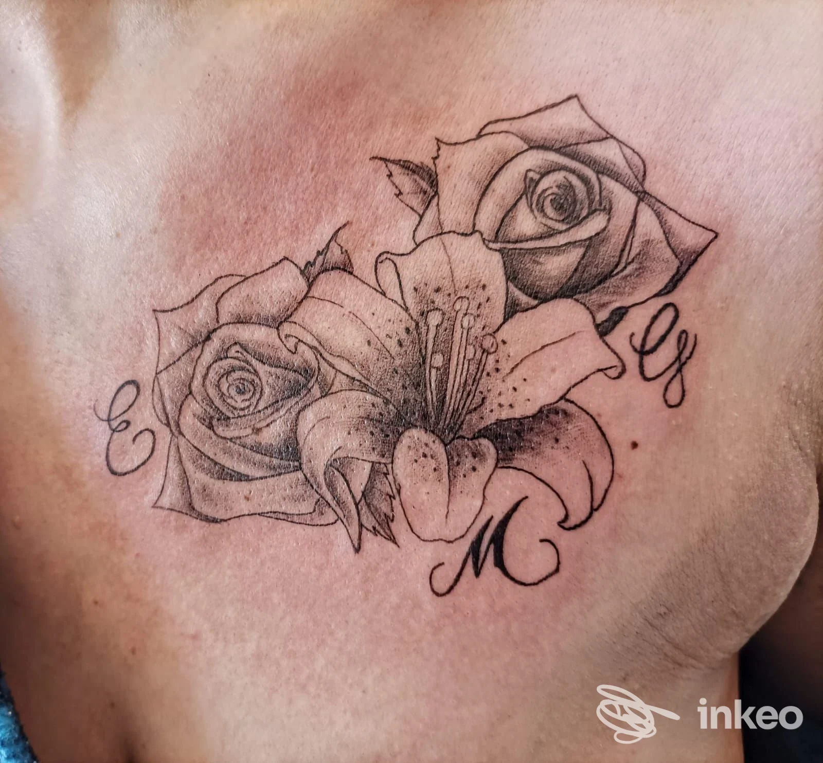 Tatuaggio a petto con due rose e un giglio in stile black & grey, scatto di Pekora Nera Tattoo Studio a Ozzano dell'Emilia.