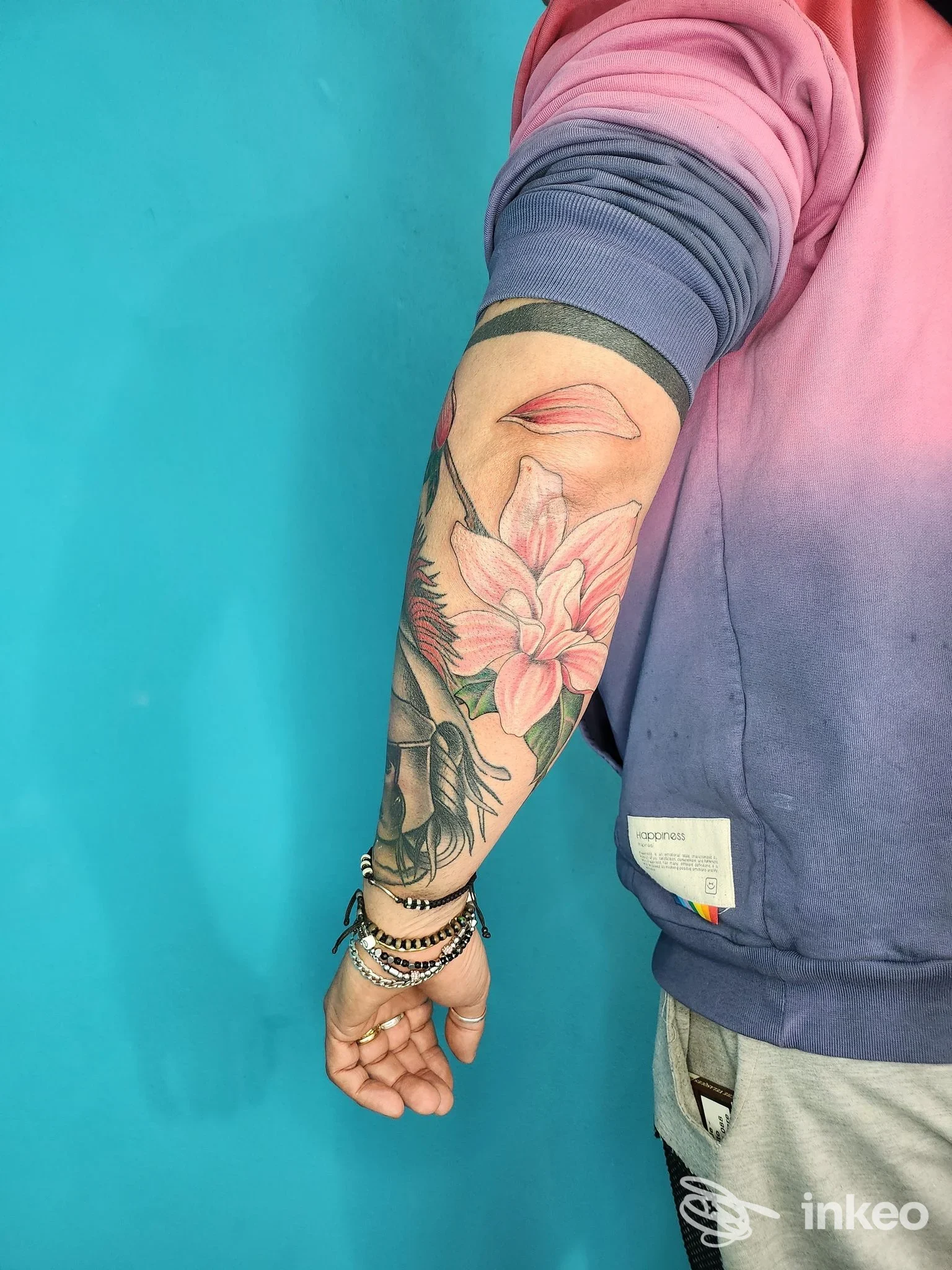Avambraccio tatuato con fiori e labbra stilizzate, foto di My Karma Tattoo Studio a Carpaneto Piacentino.