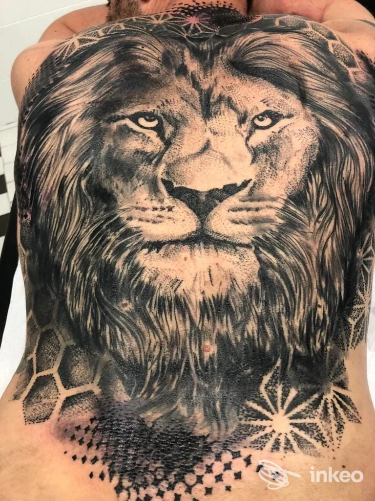 Grande tatuaggio realistico in bianco e nero di una testa di leone sul torso, Cristal Tattoo, Cesena.