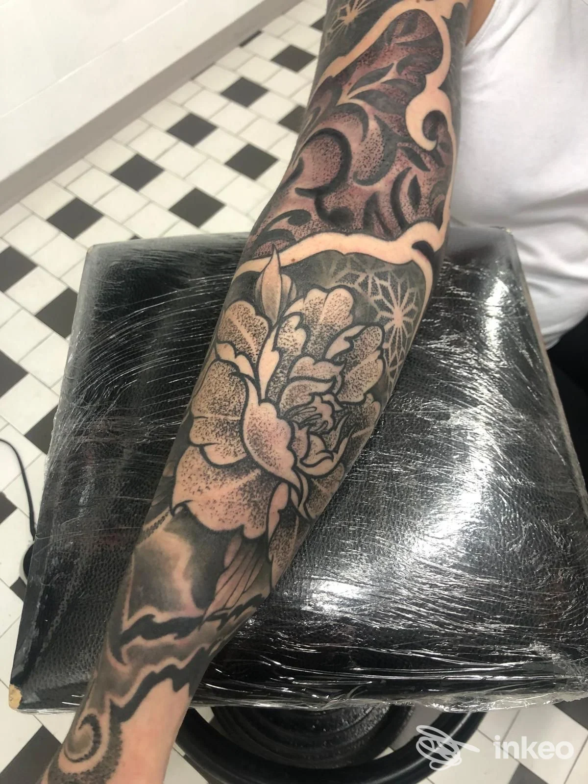 Avambraccio tatuato con fiori e motivi nero/grigio, foto fornita da Cristal Tattoo a Cesena.