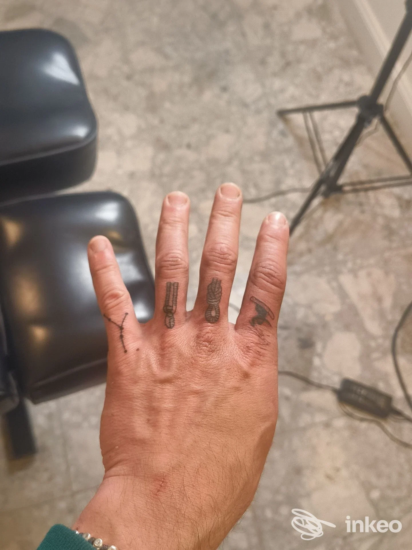 Foto della mano con piccoli tatuaggi sulle dita, scattata nello studio TUTTUNTRATTO a Bologna.