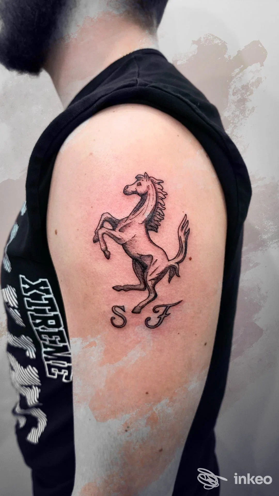 Tattoo su braccio di una persona: cavallo alzato in stile linework, colore nero, zona superiore del braccio, sfondo neutro.