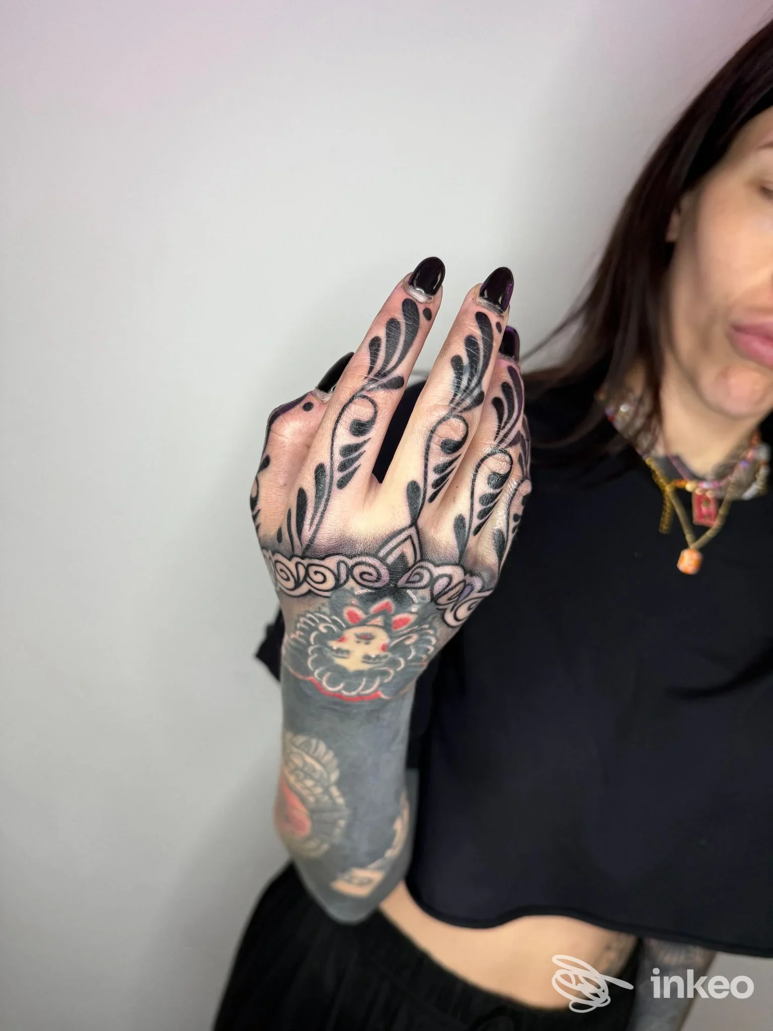 Braccio sinistro di persona con tatuaggio a tema ornato, visibile dall’avambraccio alla mano, con disegno nero spesso. nessuna interfaccia visiva o testo sovrimpresso.