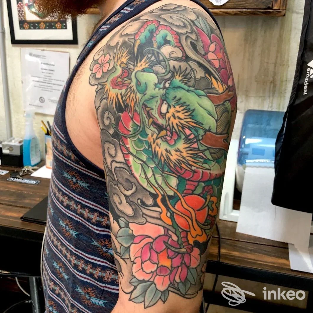 Tatuaggio a manica colorato su spalla e braccio superiore, foto dallo studio Liquid EyE Tattoo Shop a Forlì.