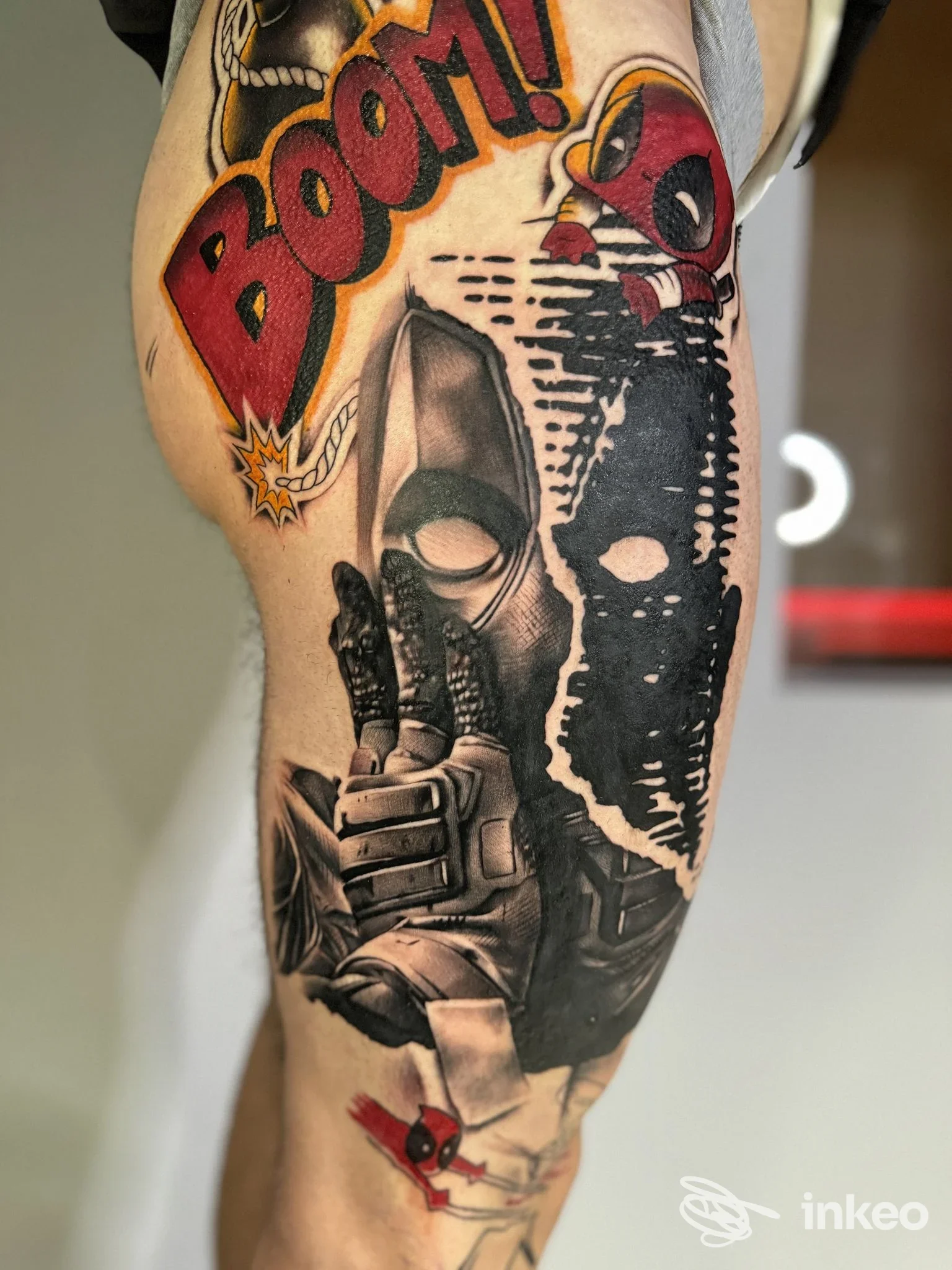 Tatuaggio su coscia con grandi motivi colorati (scritta BOOM!, maschera nera e figura Deadpool). Soul’Art Studio, Castelvetro Piacentino.