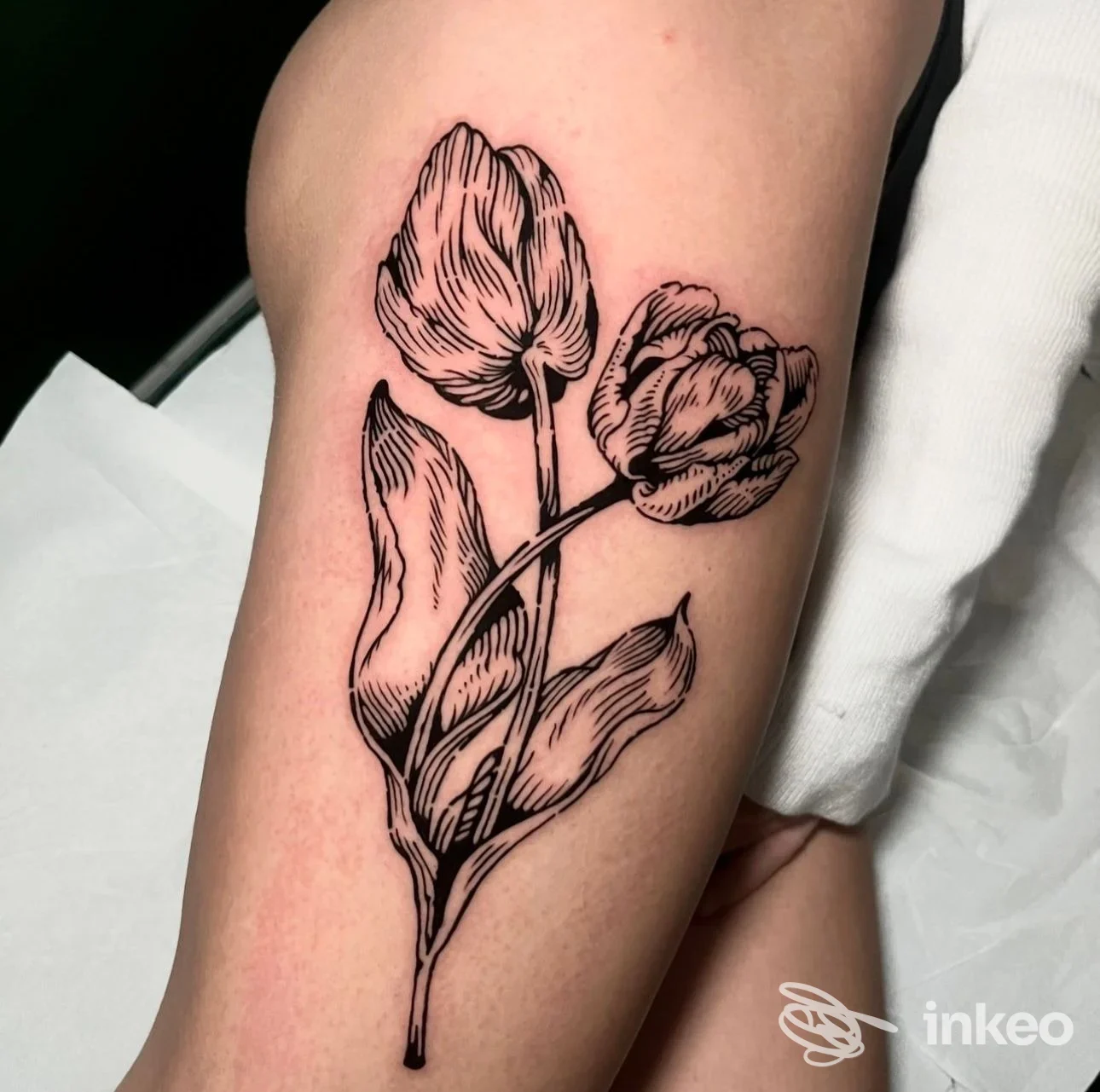 Tatuaggio a linee di due tulipani sulla coscia, foto fornita da Alchemica Tattoo, Rimini.