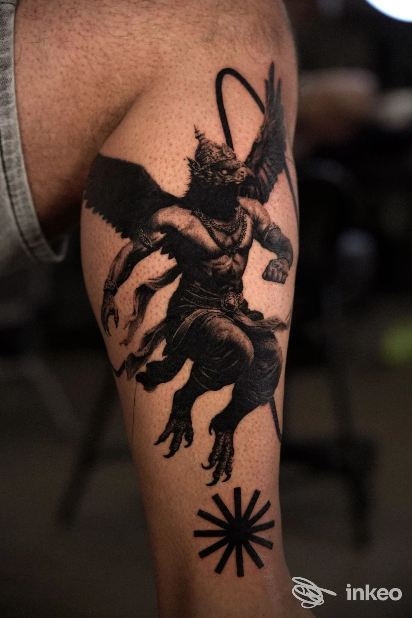 Tatuaggio realistico in nero di figura alata sul polpaccio, realizzato da Shanga Tattoo & Piercing, Cervia.