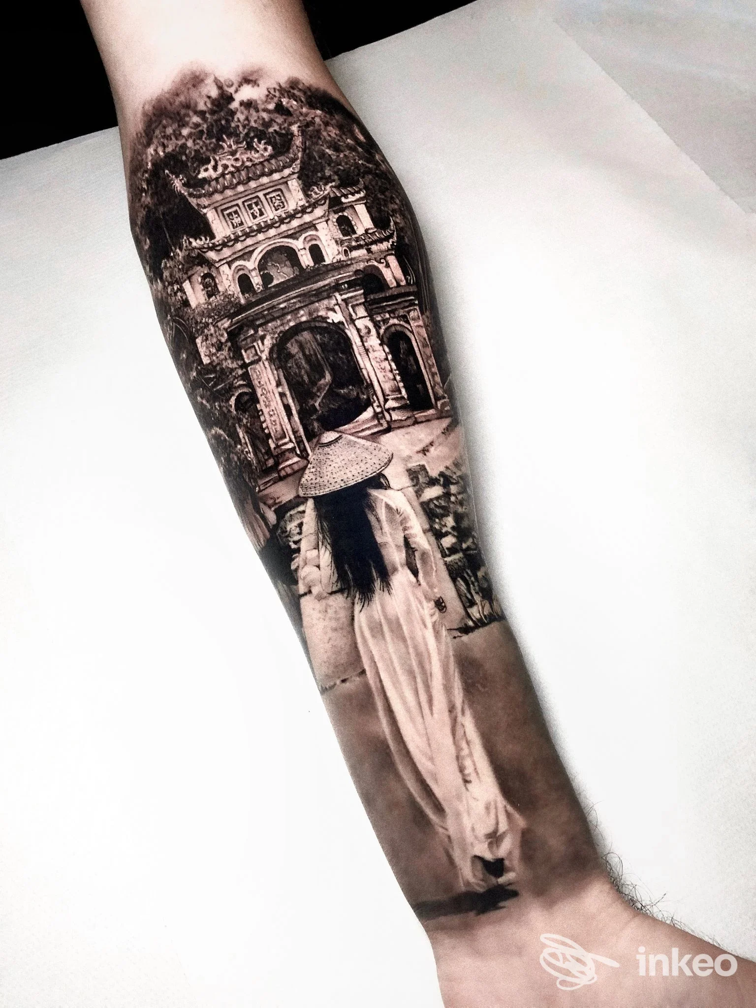 Tatuaggio realistico black & grey su avambraccio, scena con figura di spalle e porta ornamentale — Blu Banana Tattoo Studio, Cesenatico.