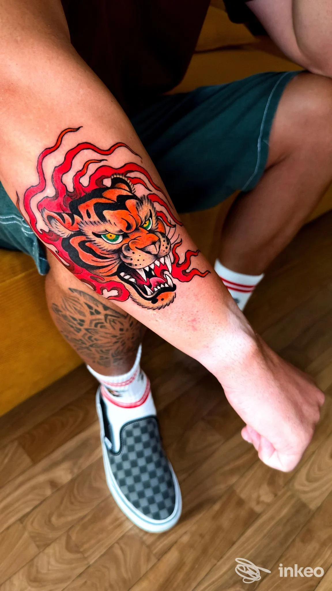 Tatuaggio a colori di una testa di tigre sull'avambraccio, realizzato da Blu Banana Tattoo Studio a Cesenatico, dettagli rossi e neri.