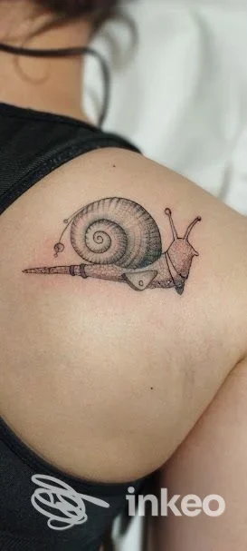 Tatuaggio raffigurante una chiocciola sulla spalla, realizzato da Lady Bulbo Lab a Calerno.