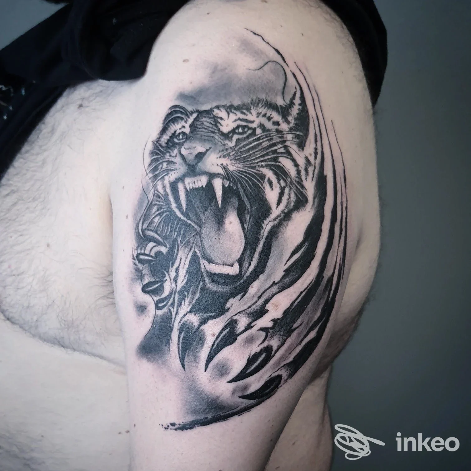 Tatuaggio in bianco e nero di una tigre ruggente sul bicipite, scatto al braccio per Art Design Ink, Cervia.