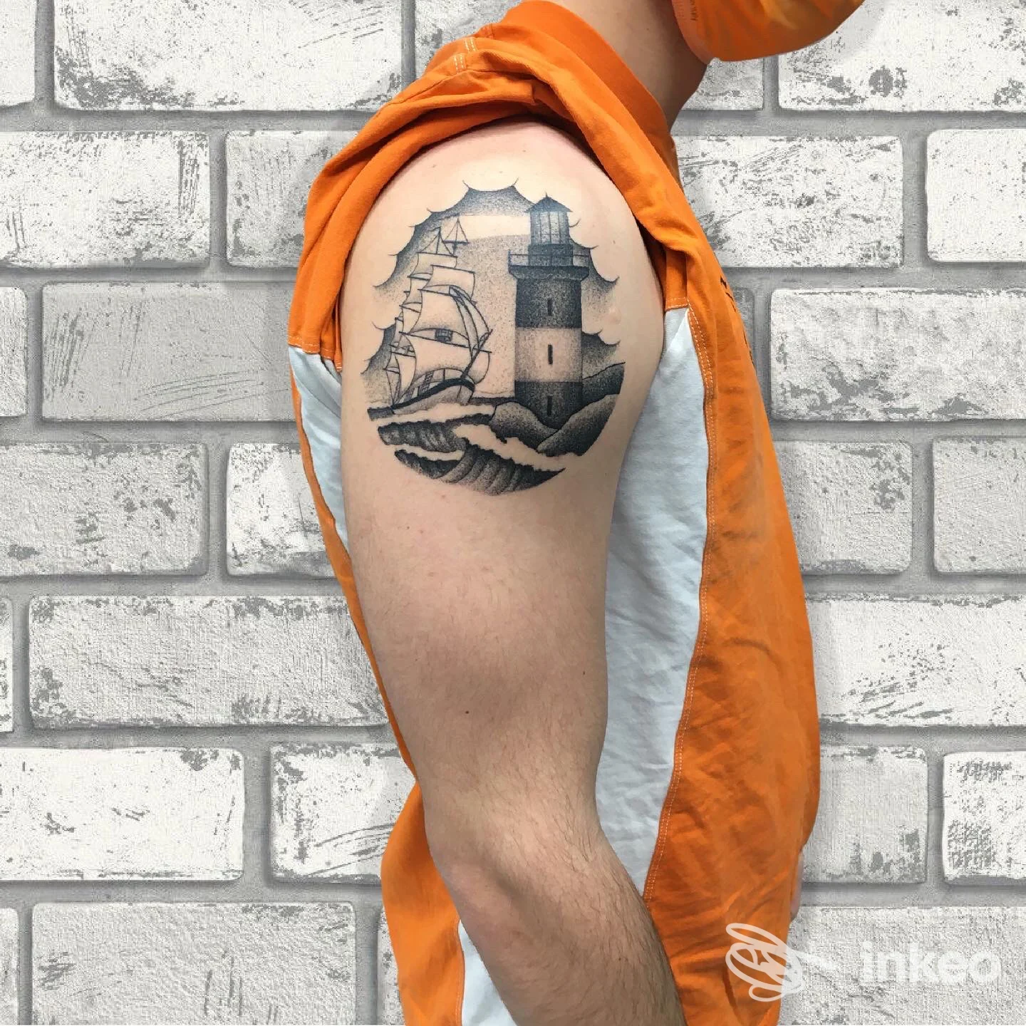 Tatuaggio black & grey di faro e nave sulla parte alta del braccio, Slow Flow Tattoo & Piercing, Reggio Emilia.