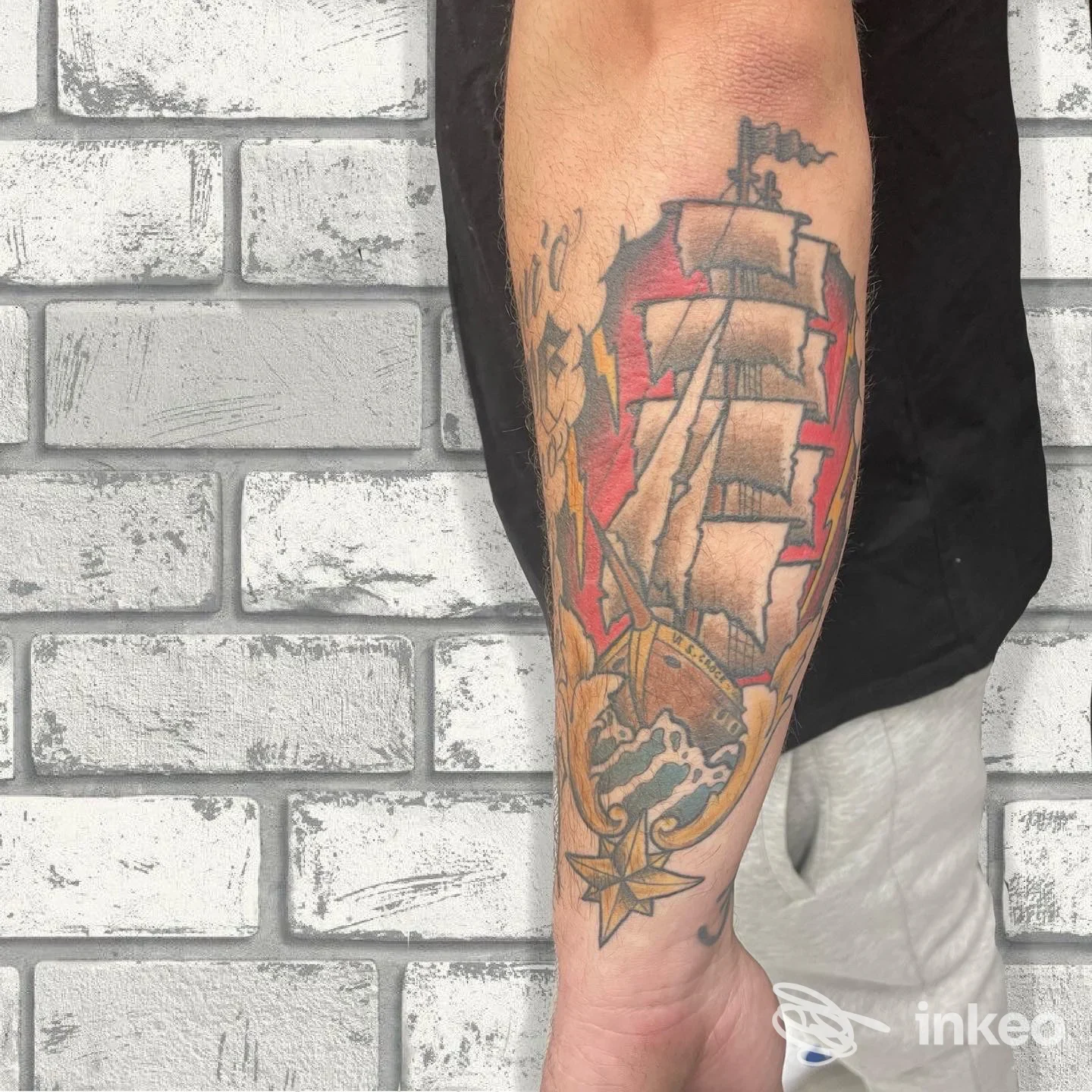 Tatuaggio a tema marina con nave a vela sull'avambraccio, foto fornita da Slow Flow Tattoo & Piercing, Reggio Emilia.