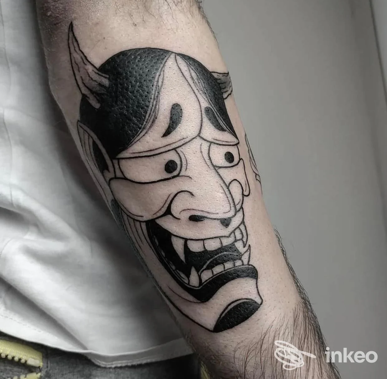Tatuaggio maschera Hannya in nero su avambraccio, realizzato da Skin Art Tattoo a Scandiano; linee nette e ombreggiature puntinate.