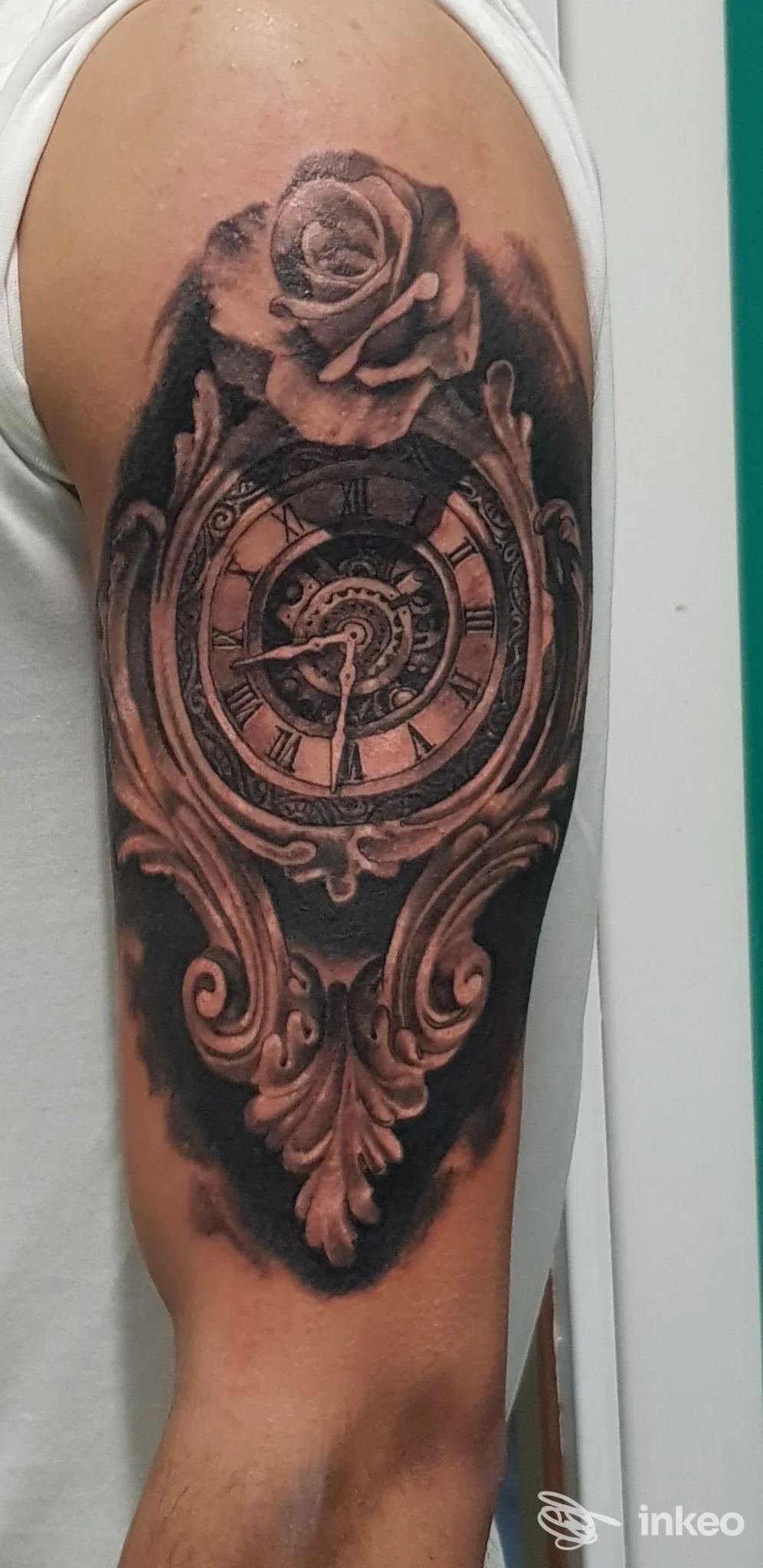 Tattoo sull'artiglio superiore raffigurante orologio rotondo con quadrante e rosa in alto, stile realistico in bianco e nero.