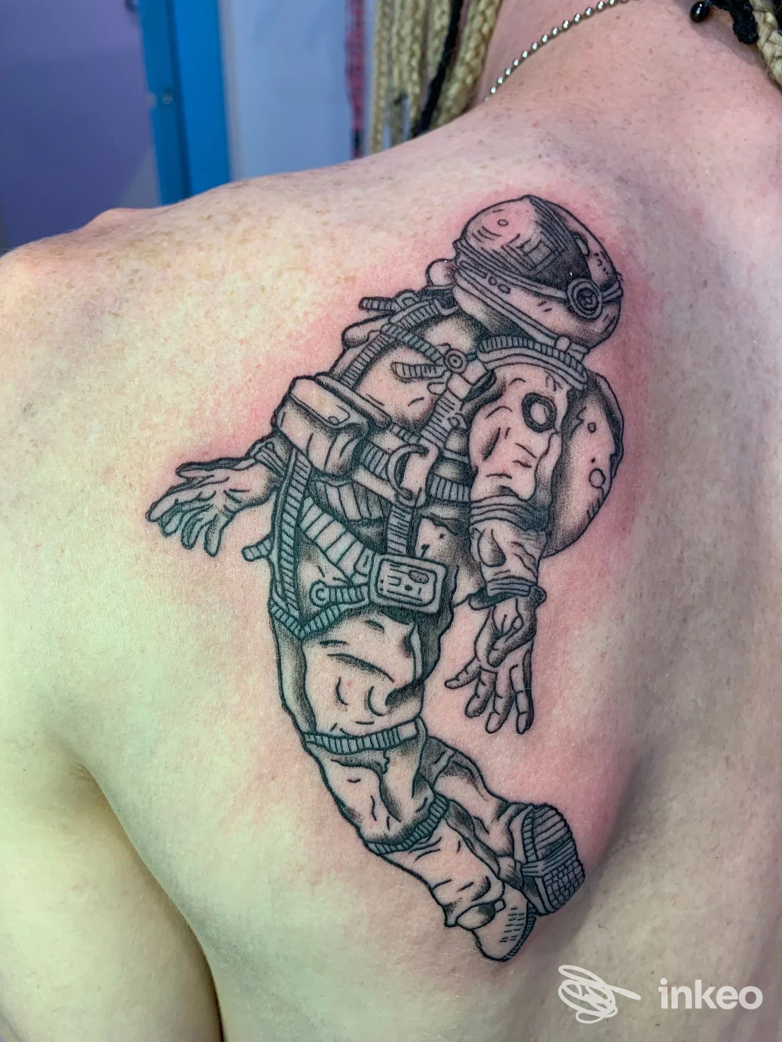 Tatuaggio a inchiostro nero/grigio di un astronauta sulla spalla superiore, realizzato da Wonderland.ink Tattoo & Piercing Studio a Bologna.