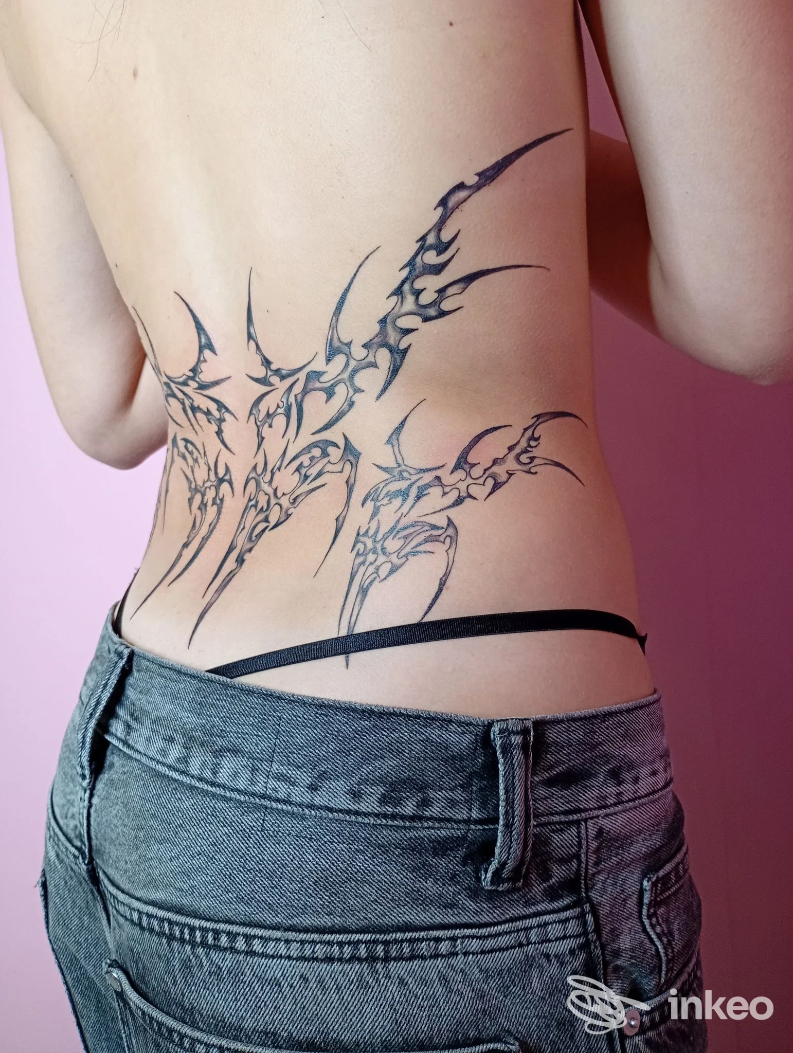 Tatuaggio tribale nero sul basso schiena fotografato in studio: Lupo Tattoo Art Studio, Felegara.