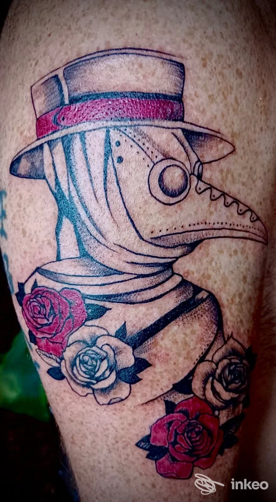 Tatuaggio su coscia raffigurante un medico della peste con cappello e rose, Lupo Tattoo Art Studio, Felegara.