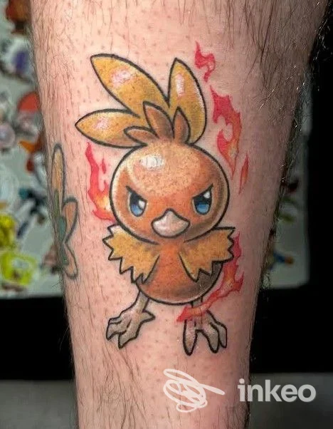 Tatuaggio di Torchic sul polpaccio realizzato da L.P.TATTOO a Carpi, colori vividi e fiamme stilizzate.
