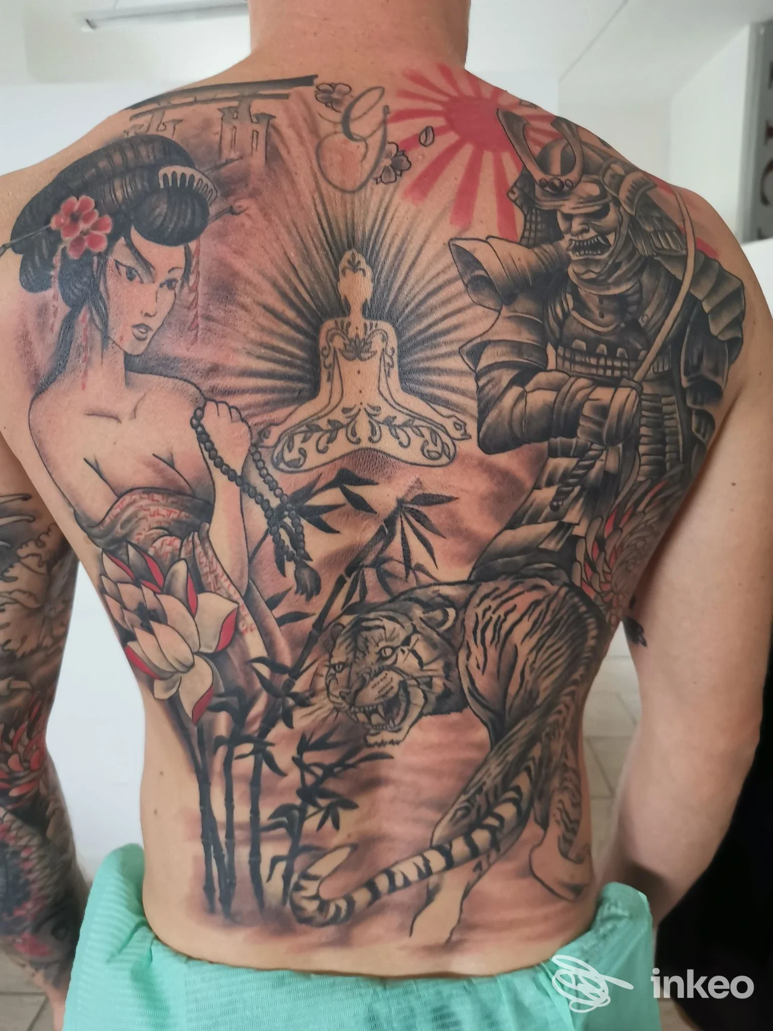 Ampia schiena tatuata con soggetti giapponesi, fotografia fornita da Picti Tattoo Shop a Piacenza.