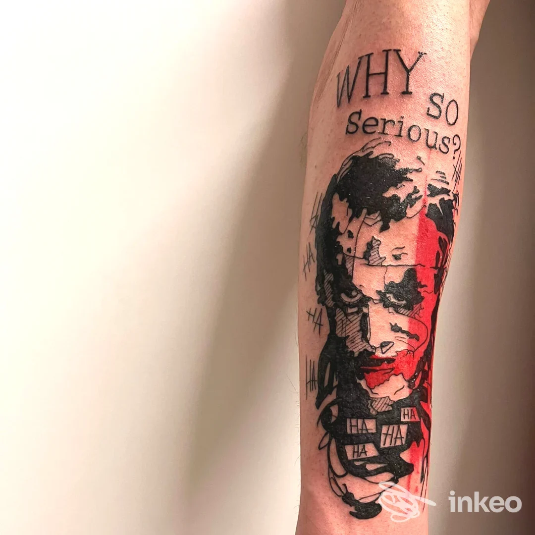 Tatuaggio reale sull'avambraccio con frase Why So Serious? e design in stile fumetto, senza overlay digitale.
