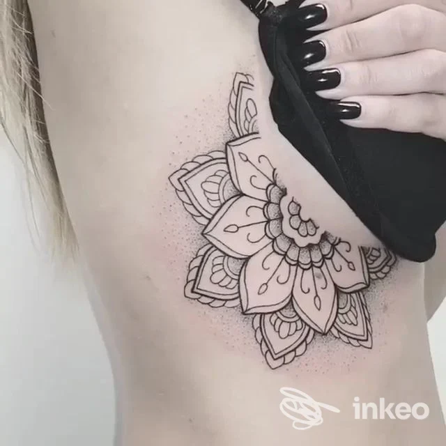 Tatuaggio mandala nero sul fianco, fotografia di Novytattoo Handmade Tattoo Studio a Carpi che mostra il lavoro sotto il seno.