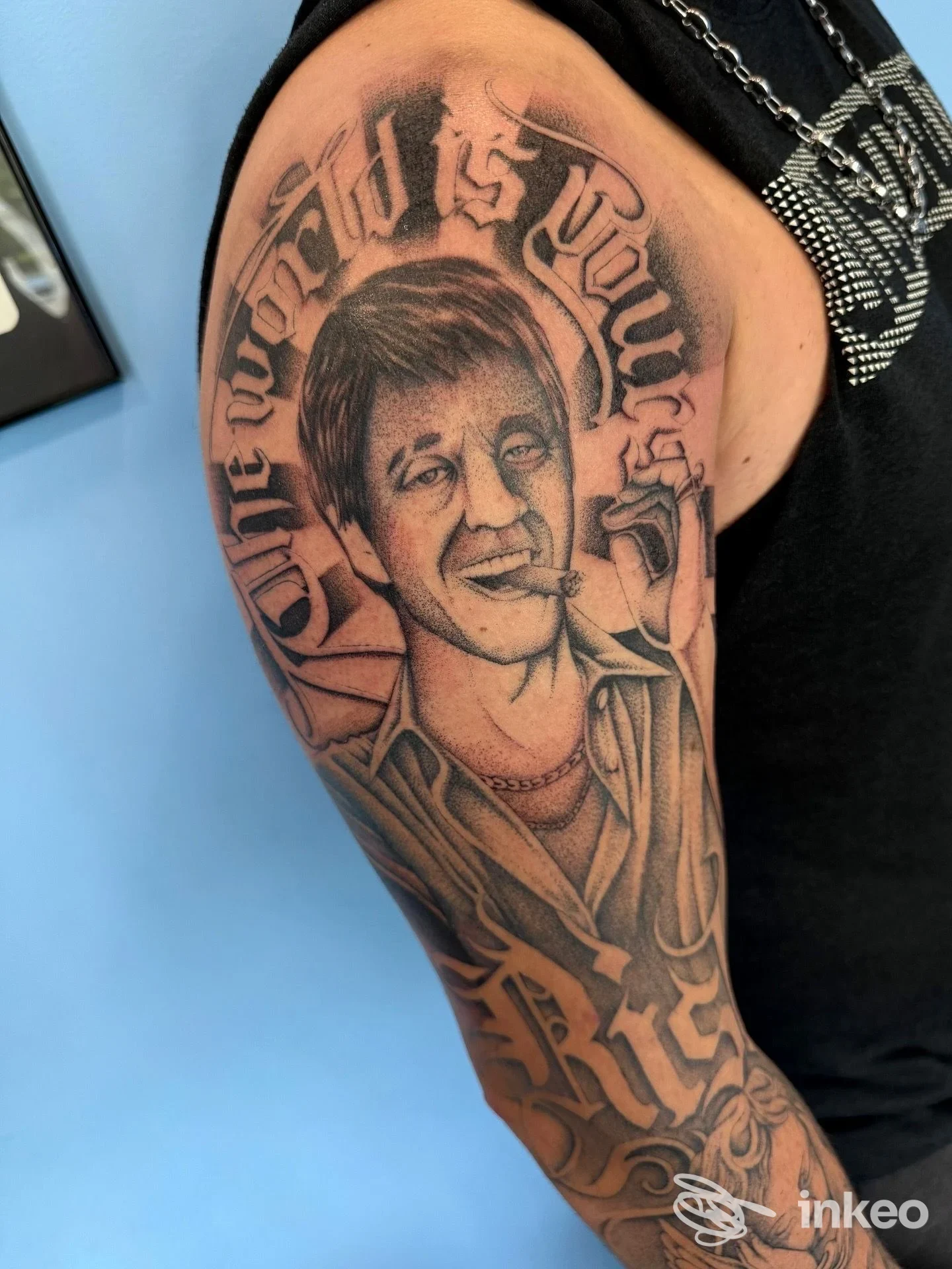Tatuaggio ritratto in bianco e nero sull'omero di un cliente, opera mostrata da Inck Tattoo & Piercing Studio a Bazzano.