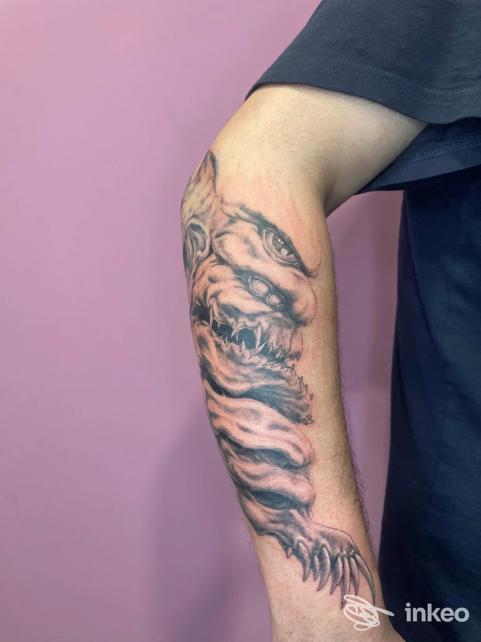 Tatuaggio in bianco e nero su avambraccio con creatura dentata, foto fornita da Inck Tattoo & Piercing Studio, Bazzano.