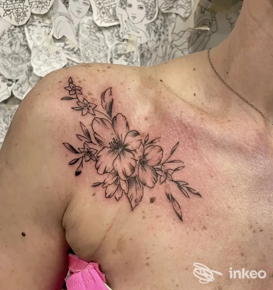 Tatuaggio floreale nero su spalla e clavicola, fotografia dallo studio No Remorse Tattoo Studio a Reggio nell'Emilia.