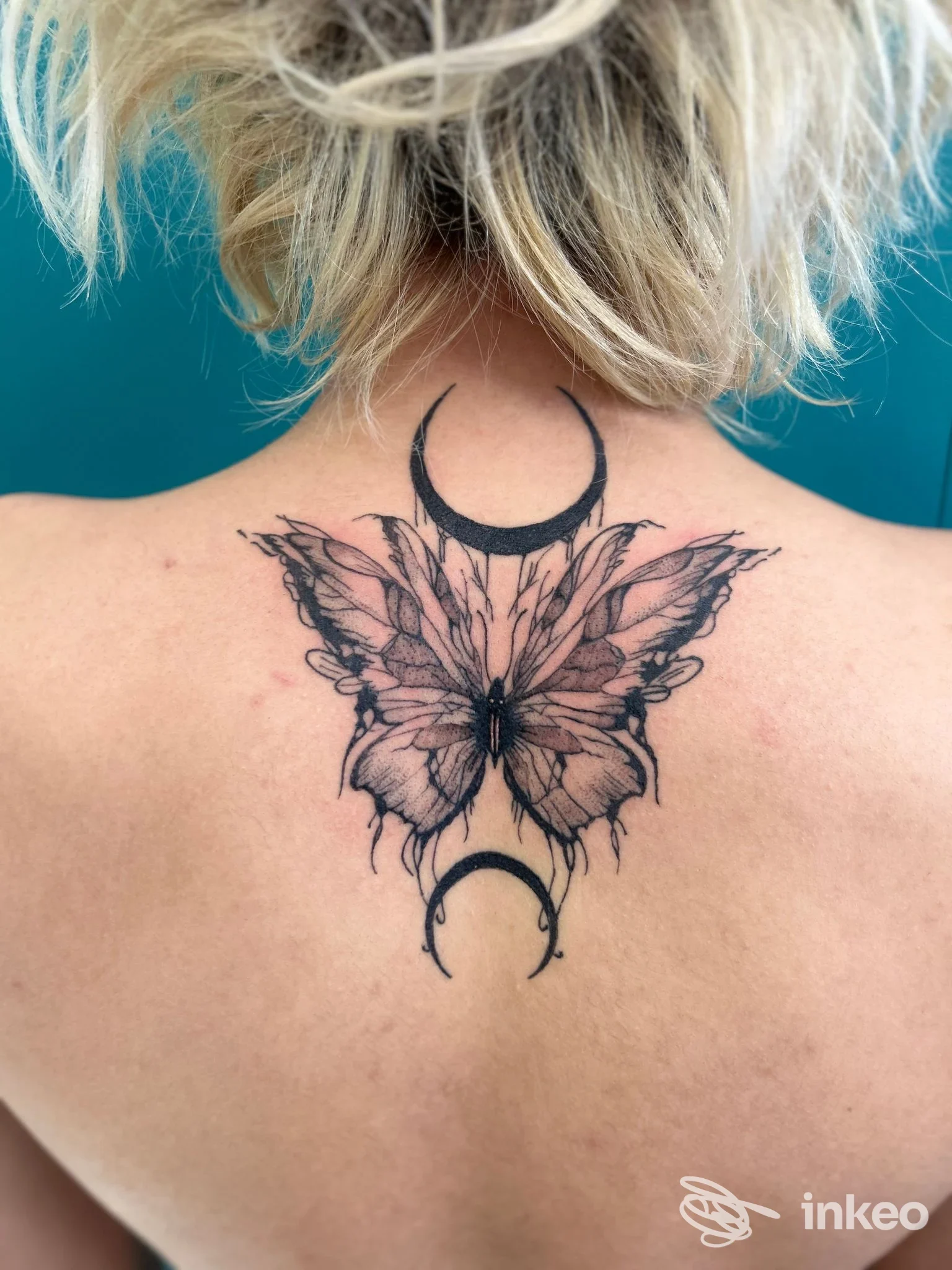 Tatuaggio farfalla con lune sulla parte alta della schiena, fotografato a Natattoo Studio a Forlì.