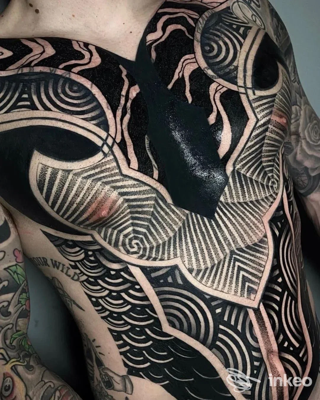 Ampio tatuaggio geometricoblackwork su torace e braccio, fotografia di copertura realizzata da Eleven ink Piacenza, Piacenza.