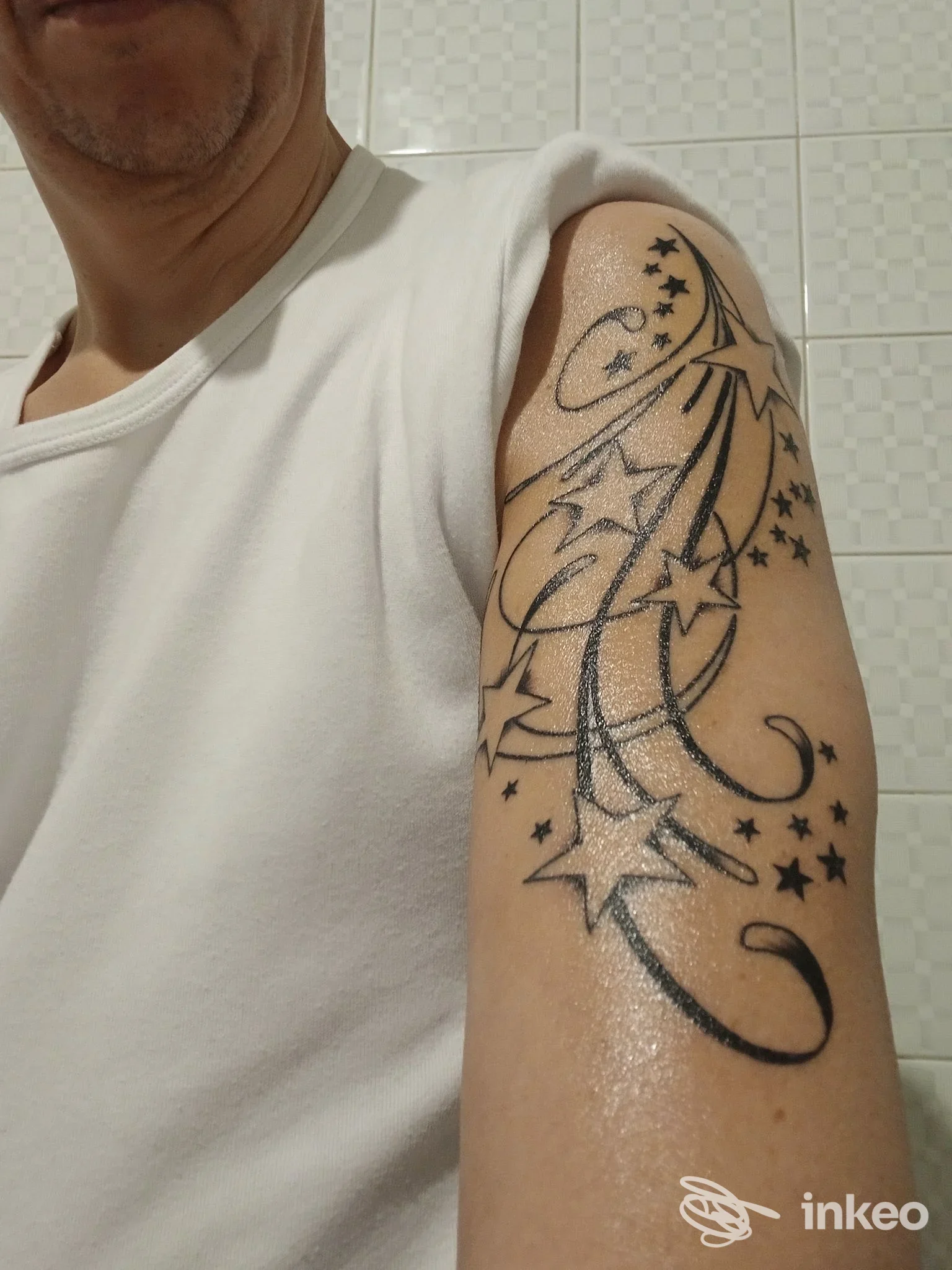 Braccio maschile con tatuaggio a stelle e linee sul bicipite, foto scattata per Green Frog Tattoo Parlour a Bellaria-Igea Marina.